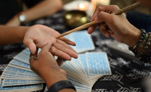 close-up-fortune-teller-reading-palm-forecasting-future-client-dark-room-divination-concept-scaled-e1735558348780-1024x623.jpg